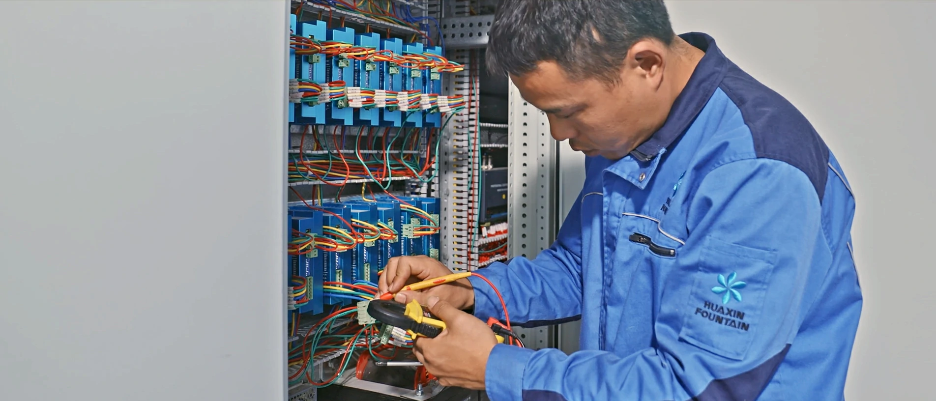 Huaxin Fountain engineer installing control cabinet components and internal wiring