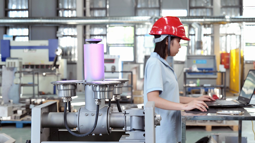 Technician using a laptop beside a Huaxin integrated variable fountain nozzle with illuminated RGB lights