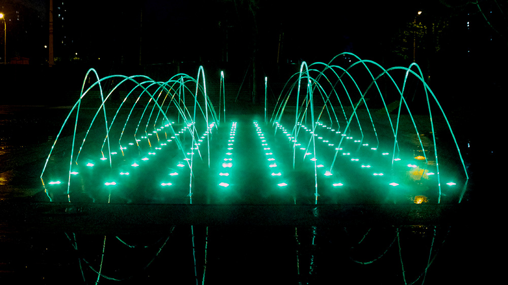 Continuous laminar water arcs arranged along a linear fountain layout